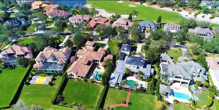 Luxury waterfront estate in Windermere, FL with lush landscaping and modern architecture